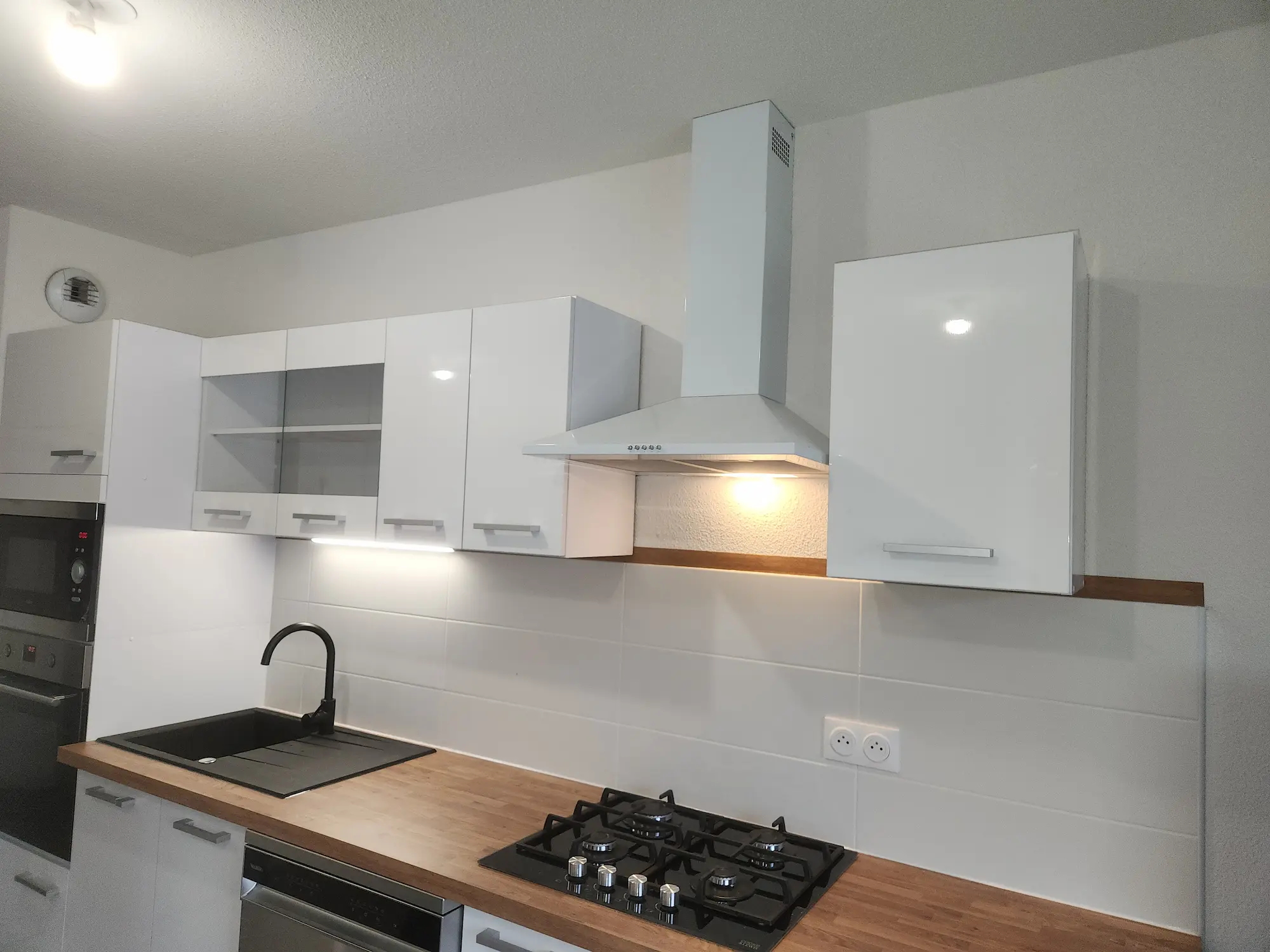 Cuisiniste Montpellier – cuisine blanche plan de travail bois hotte aspirante