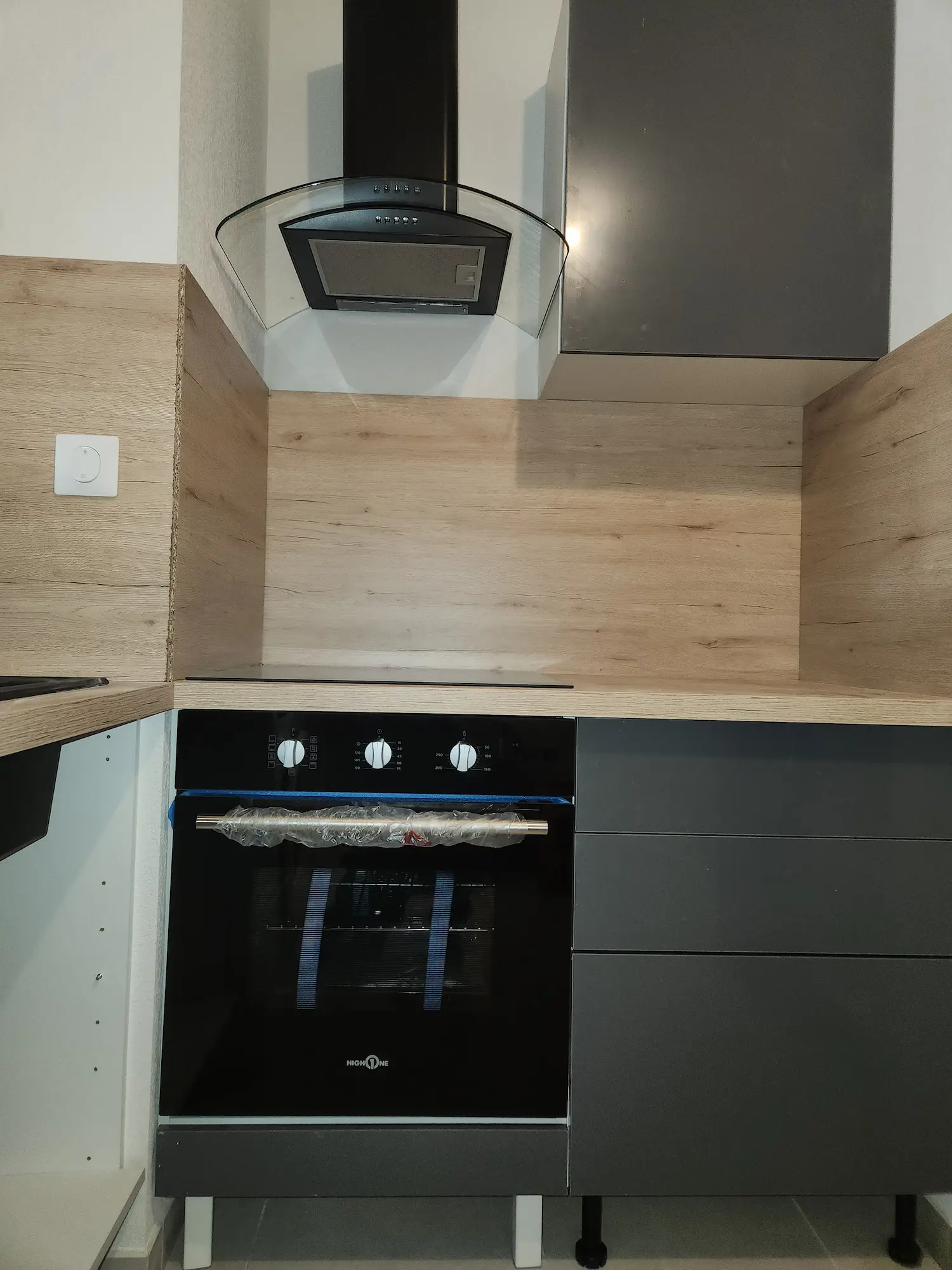 Cuisiniste Montpellier – cuisine anthracite four noir hotte verre crédence bois